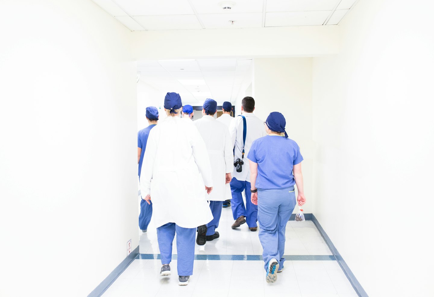 Medizinisches Personal geht einen Krankenhausflur entlang.